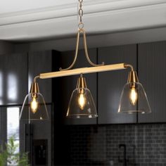 three lights hanging from the ceiling in a kitchen