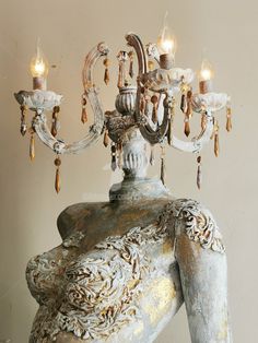 an ornate chandelier hangs from the ceiling in front of a white wall and floor