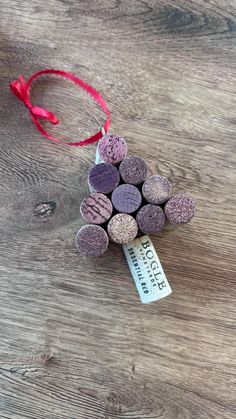 a bunch of wine corks sitting on top of a wooden table next to a red ribbon