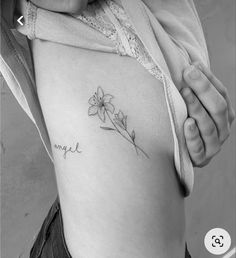 a woman's stomach with a flower tattoo on it