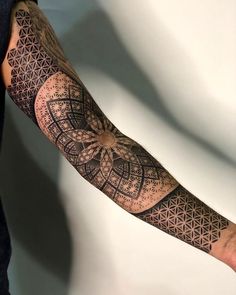 a man's arm with an intricate tattoo design on the forearm and hand area