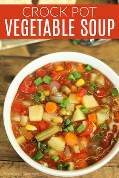 a white bowl filled with vegetable soup on top of a wooden table