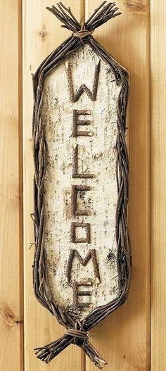 a sign that says welcome hanging on a wooden wall