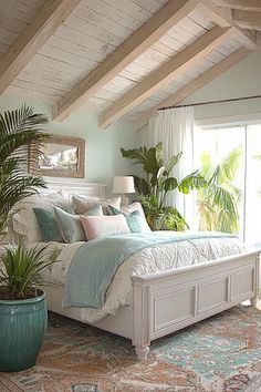 a bedroom with a large bed and potted plants