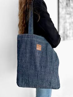 a woman carrying a denim tote bag