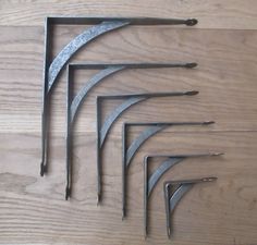 five metal tools are laying on a wooden surface