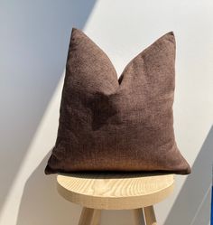 a brown pillow sitting on top of a wooden stool