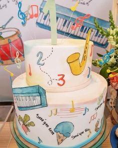 a three tiered cake decorated with musical instruments and music notes on the bottom layer