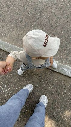 two people holding hands while standing next to each other on the street with their feet in the air