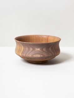 a wooden bowl sitting on top of a white table