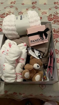 a box filled with lots of diapers and stuffed animals sitting on top of a bed