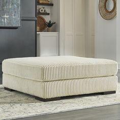 a white ottoman sitting on top of a rug