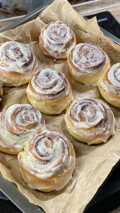 there are many cinnamon rolls on top of each other in the tray, ready to be eaten