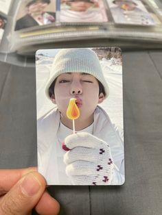 a person holding up a photo with a candle sticking out of it's mouth