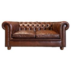 a brown leather couch sitting on top of a white floor