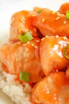 chicken with sauce and green onions on top of rice