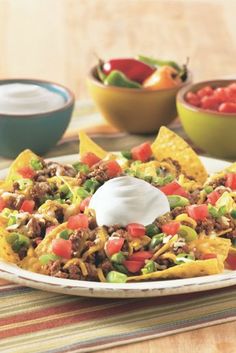 a plate with nachos and sour cream on top