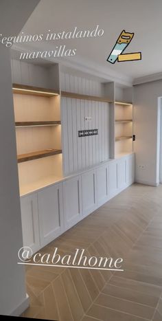 an empty room with white cabinets and shelves