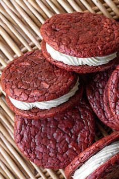 red velvet cookies with white frosting are stacked on top of each other in a wicker basket