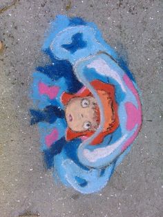 a child's drawing on the ground with blue and pink colors