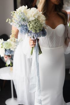 a woman in a white dress holding a bouquet of flowers