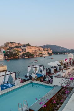 an outdoor swimming pool next to the water