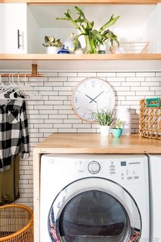 a washer and dryer in a small room with shelves above the washer