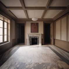 an empty room with a fireplace and large windows