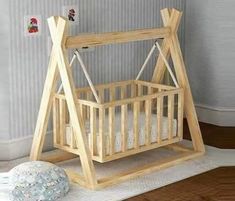 a wooden baby crib next to a ball on the floor