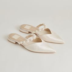 two pairs of white shoes with pearls on the toe and heel, all in satin