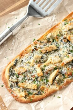 a pizza sitting on top of a piece of paper next to a knife and fork