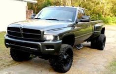 a large black truck parked in front of a house