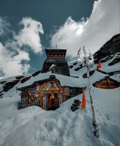 a snow covered mountain with a building in the middle