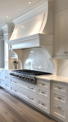 a large kitchen with white cabinets and marble counter tops on the stove top is shown