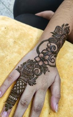 a woman's hand with henna tattoos on it