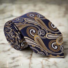 Elevate Your Style: Blue Necktie with Yellow Gold Paisley Pattern Indulge in sophistication and timeless elegance with our striking blue silk necktie, adorned with an intricate yellow gold paisley pattern that effortlessly blends charm and refinement. 1. A Tale of Elegance: Embracing the Blue & Gold Paisley This silk necktie weaves a story of opulence, the deep blue canvas beautifully accented by the golden paisley pattern, adding an air of sophistication to your attire. 2. Dress Shirt Pairings: Paisley Color, Blue Necktie, Gold Paisley, Paisley Tie, Tie Set, Silk Necktie, Blue Canvas, Blue Silk, Tie And Pocket Square