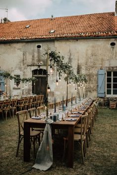 an outdoor dining area with tables and chairs set up for a formal function in front of a building