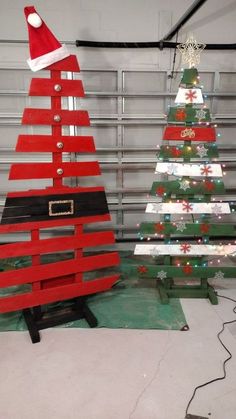 two wooden christmas trees with santa hats on them