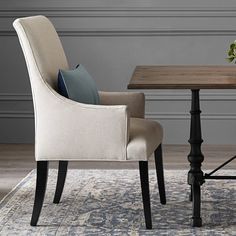 a dining room table with two chairs and a rug on the floor next to it