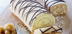 there is a cake roll with white frosting and chocolate drizzled on it