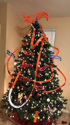 a decorated christmas tree with orange ribbon