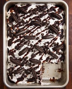 an ice cream dessert with oreo cookies and chocolate on top, in a pan