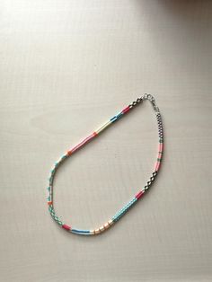 a multicolored beaded necklace on a white surface