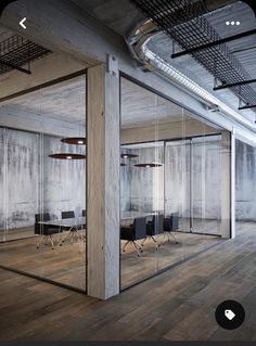 an empty office with glass walls and chairs in the middle is seen from across the room