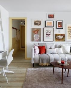 a living room filled with furniture and pictures on the wall