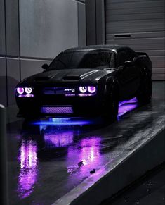 a black car with purple lights on the hood