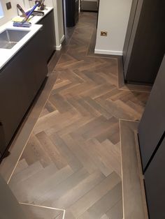 a kitchen with wood flooring next to a sink and stove top oven in it