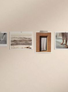 a woman standing in front of a wall with pictures hanging on it's side