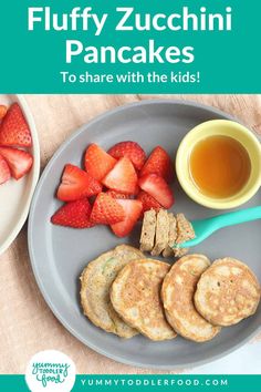 a plate filled with pancakes and strawberries next to a cup of tea