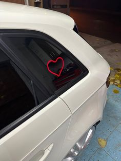 a white car with a red heart on the window